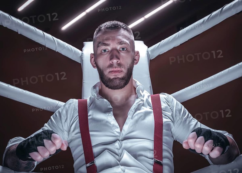 Images of a bearded man in a white shirt and red suspenders in the ring. The concept of fist underground fights.