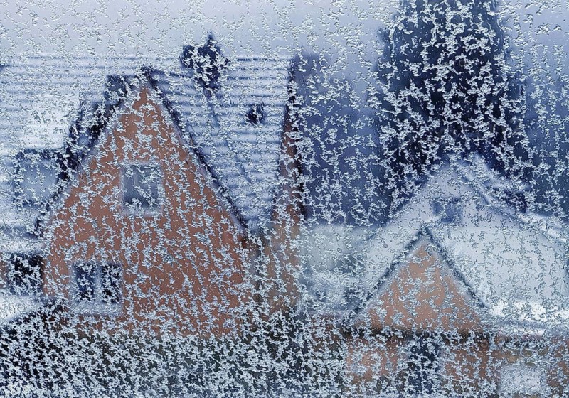 Ice on a window pane with indistinct view of a house in winter, Witten, North Rhine-Westphalia, Germany