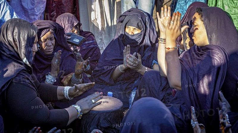 Women drumming and praying in a close community, intense emotions, traditional woman make music at the Tuareg Festival of Tamanrasset in the Sahara in Algeria
