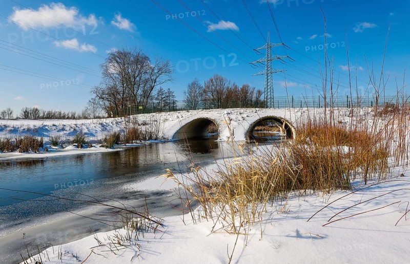 Bottrop, North Rhine-Westphalia, Germany - Sunny winter landscape in the Ruhr area, ice and snow on the renaturalised Boye, the small river is being renaturalised, is being transformed into a near-natural body of water, the Boye is part of the Emscher river system and thus part of the Emscher conversion, was previously an open, above-ground wastewater canal, mixed water canal with surface water and wastewater