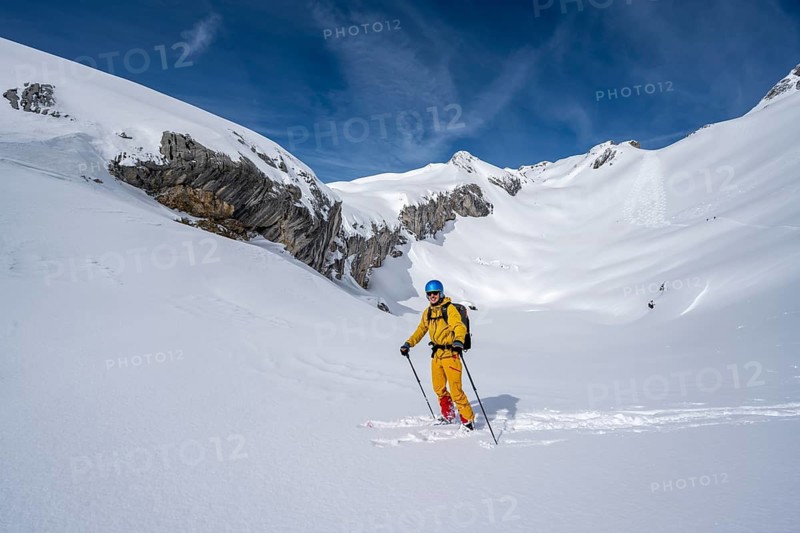 Ski tourers descending in fresh snow, mountain landscape in winter, Bernese Alps, Switzerland