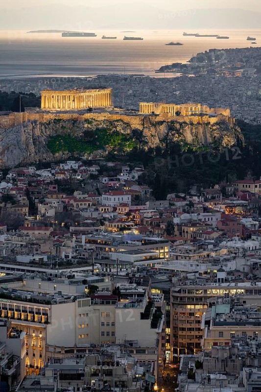 View over the sea of houses of Athens, illuminated Parthenon temple on the Acropolis, from Mount Lycabettus, Athens, Greece