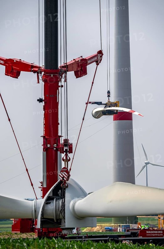 Dismantling of a wind power plant in a wind farm near Issum, 9 older wind turbines from the manufacturer Enercon (model series E-58), front, blades being dismantled, were in operation for over two decades, will be replaced by a total of four Enercon E-160 turbines, rear, assembly of the first blade, with a total output of 22 megawatts, Lower Rhine, North Rhine-Westphalia, Germany