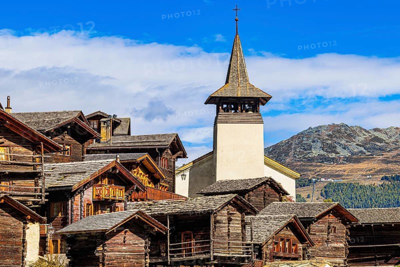Old wooden houses and the Saint Theodule church in the historic village centre, Grimentz, Val d'Anniviers, Valais Alps, Canton Valais, Switzerland