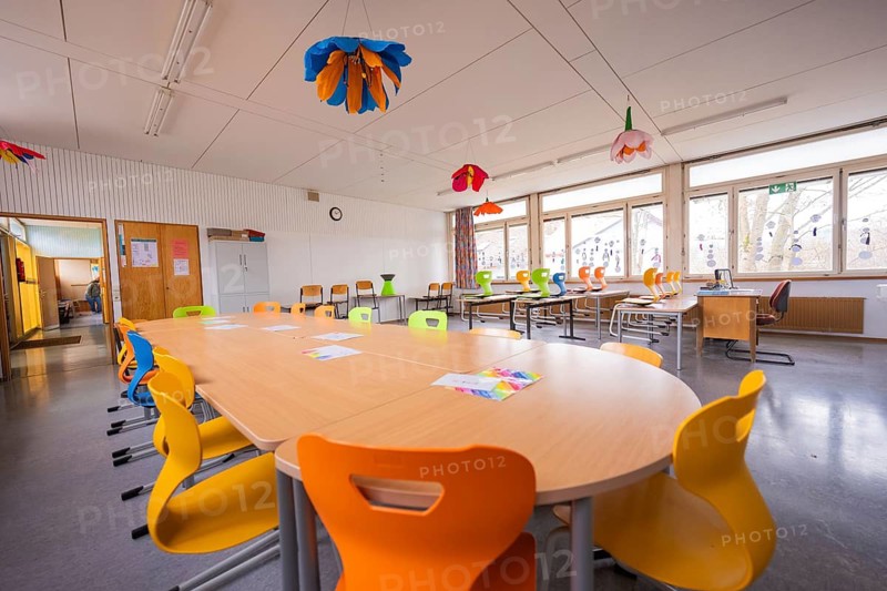 Classroom with long tables, colorful chairs and lampshades on the ceiling, homework supervision, Schlehengäu Grund Schule Gechingen, Calw district, Germany