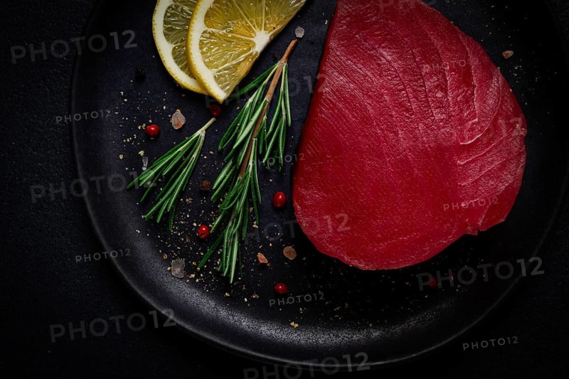 Fresh red tuna fillet, for steak, raw, top view, on a black plate, no people