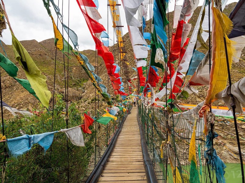 Suspension bridge with prayer flags, highlands of Tibet, China