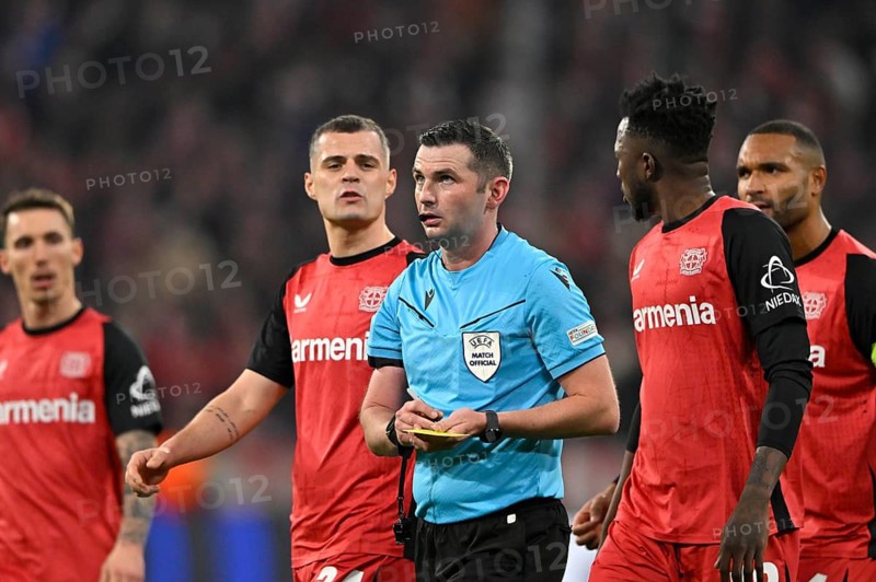 Referee Michael Oliver (ENG) notes yellow card yellow caution Granit Xhaka Bayer 04 Leverkusen (34) Edmond Tapsoba Bayer 04 Leverkusen (12) Jonathan Tah Bayer 04 Leverkusen (04) Alejandro Grimaldo Bayer 04 Leverkusen (20) UEFA Champions League Allianz Arena, Munich, Bavaria, Germany