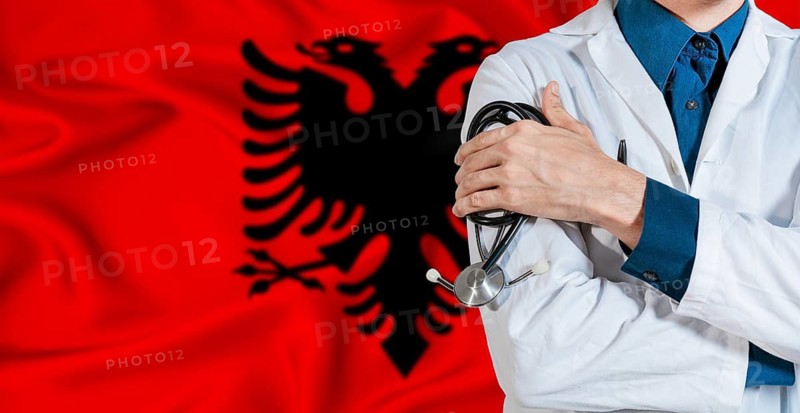 Doctor with stethoscope on Albania flag. Doctor holding stethoscope on Albania flag