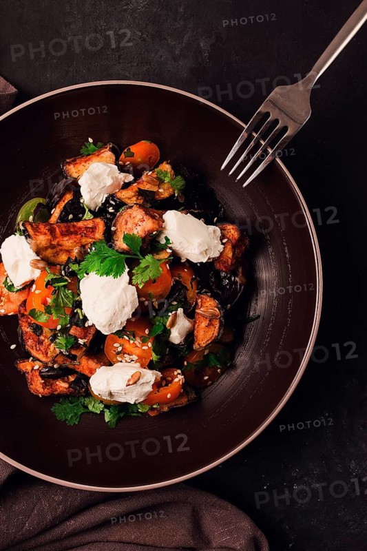 Warm Salad with crispy eggplant and tomatoes, cottage cheese, spices, herbs, sesame seeds, sunflower seeds, Georgian cuisine, no people