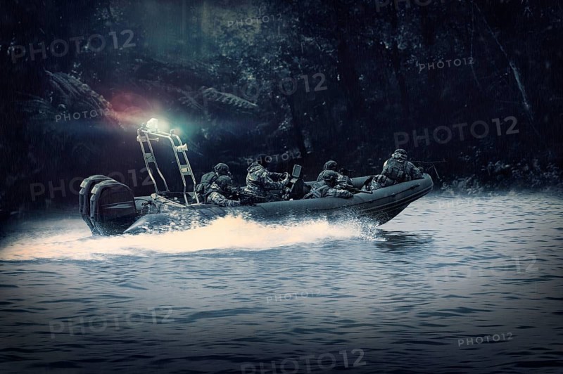 Group of military fighters on a boat with a flasher are chasing pirates. The concept of sea robberies, piracy, poaching.