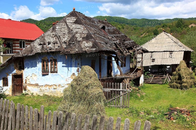 Traditional Romanian farmhouse that is in a dilapidated or abandoned state. The eye-catching light blue color of the outer walls is common in many Romanian villages, such houses are characteristic of rural regions in Romania, particularly Transylvania, Transylvania