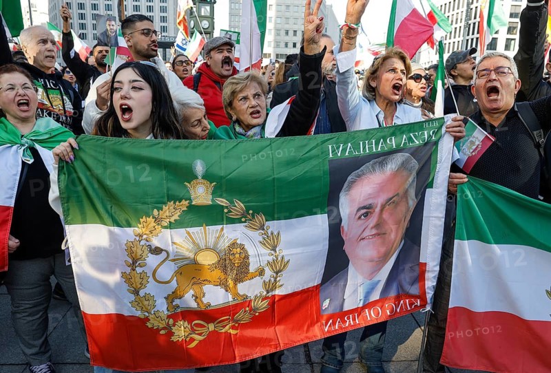 Iranians demonstrate with a poster of Prince Reza Pahlavi on the day of the US and Israeli attack on Iran, Berlin, 28.02.2026. People wave flags of the Iranian monarchy, German, Israeli and US flags, Berlin, Berlin, Germany