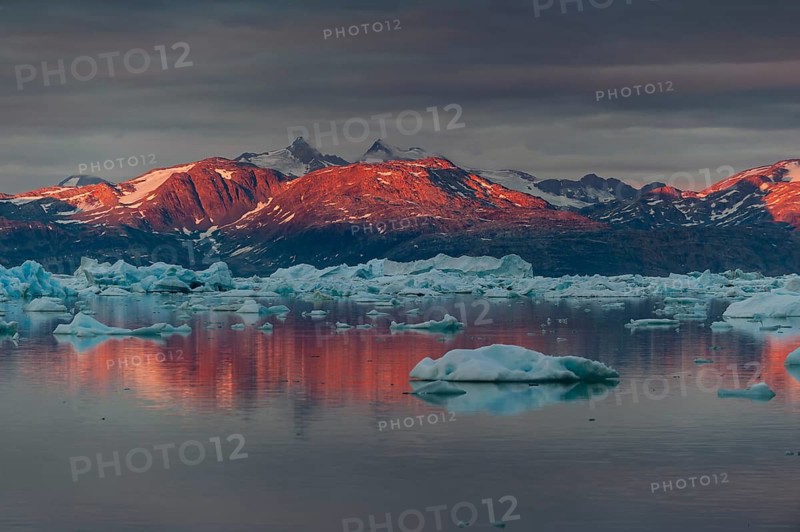 Midnight sun on mountain range, Johan Petersen Fjord, East Greenland, Greenland