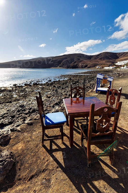 Wooden table and four chairs, fish restaurant on the beach, coastline, Playa Quemada, Yaiza, Lanzarote, Spain