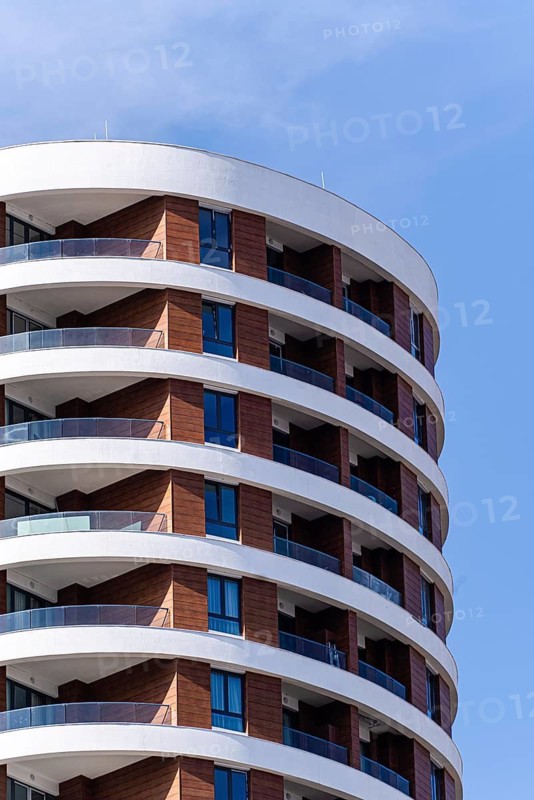 A modern architectural marvel showcasing the seamless integration of glass and concrete, creating a striking facade in an urban suburb