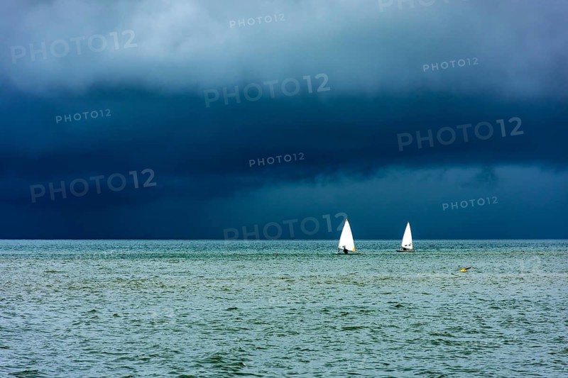 Sailboats sailing the waters of the sea of ??Ilhabela island before the storm, Ilhabela, Sao Paulo, Brazil