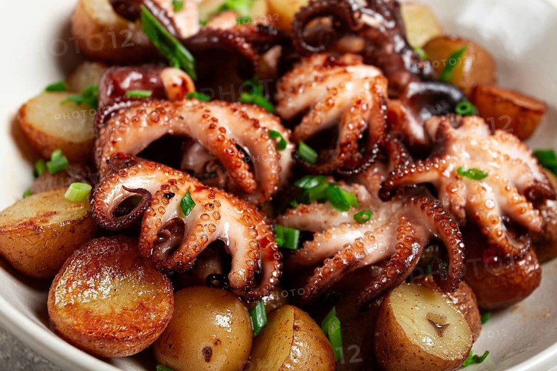 Baby grilled octopus with golden baked potatoes and fresh herbs, Maltese cuisine, homemade, no people