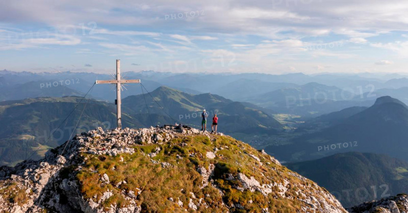 Two hikers at the summit, aerial view, evening mood in the mountains, summit cross of the Schaffauer, Wilder Kaiser, Tyrol, Austria