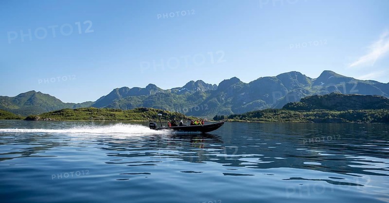 Motorboat with tourists sailing on the Sund Raftsund, fjord landscape with mountains, Lofoten, Nordland, Norway
