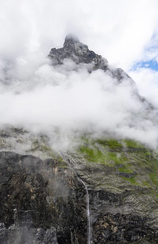Cloud-covered mystical gorge with waterfall and mountain peak, hiking to Berghaus Bäregg, Bernese Alps, Bernese Oberland, Switzerland