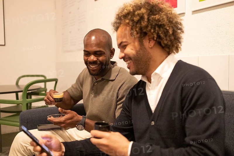 Two professionals enjoy a casual coffee break in a stylish coworking space in Barcelona. This modern office setting fosters creativity, collaboration, and networking opportunities