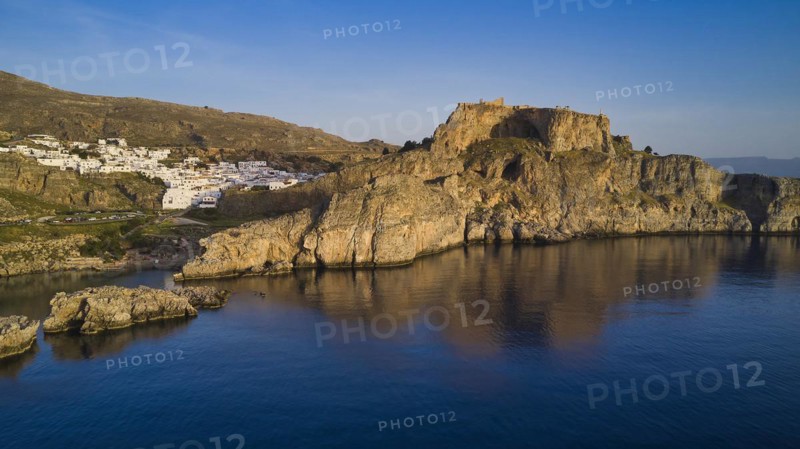 Drone shot, first morning light, Lindos, Acropolis of Lindos, Fortress on a rocky coast above the azure blue sea under a clear sky, Archaeological site, Lindos, Rhodes, Dodecanese, Greek Islands, Greece