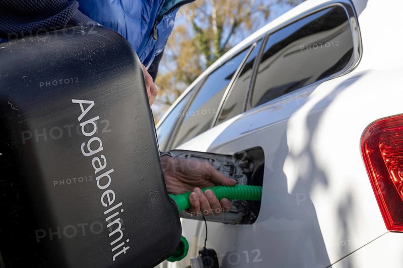 Symbolic image of energy shortage: Filling a car with petrol canisters (digitally reworked)