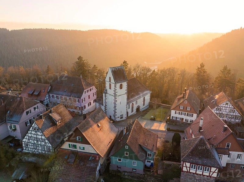 A village with half-timbered houses and church in soft light embedded in a natural landscape, Zavelstein, district of Calw, Black Forest, Germany