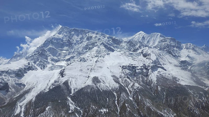 Majestic snow-capped mountains under a clear blue sky in the Himalayas, trekking at Annapurna Circuit, Manang, Nepal