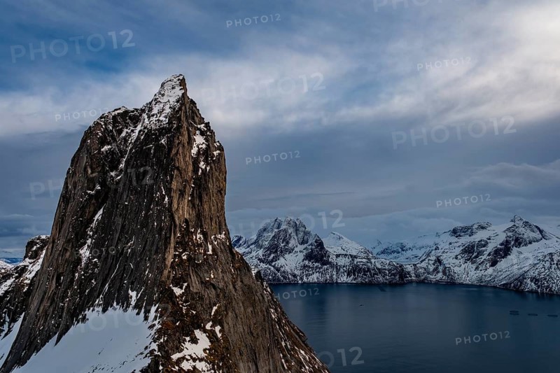 Steep mountain Segla, Mefjorden fjord with snowy mountains, Senja island, Troms, Norway
