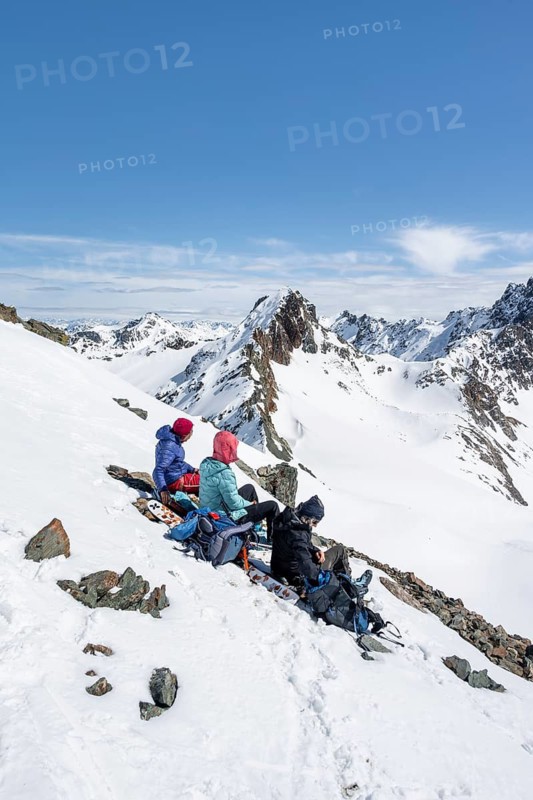 Ski tourers taking a break at the summit, on the Graubünden Haute Route, Scalettahorn, Snow-covered mountains, Winter in the Albula Alps, Graubünden, Switzerland