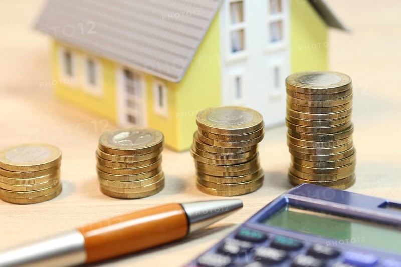 Concept photo with model house and coins