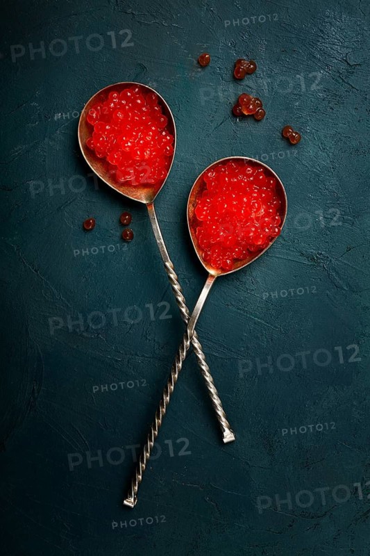 Spoons with red caviar, imitation, on a dark background, no people