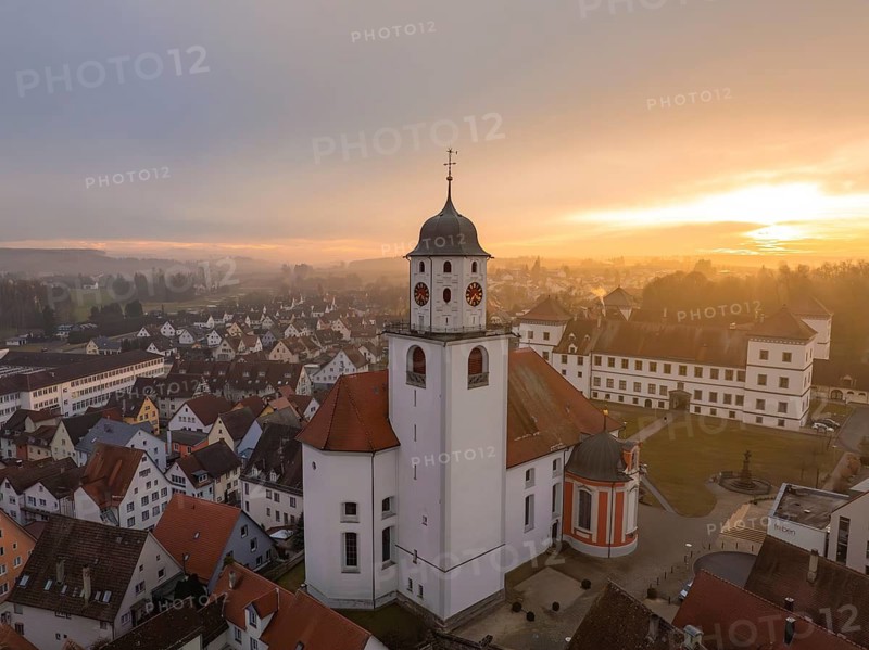 Church in a village at sunset with red roofs and cloudy sky, Meßkirch, district of Sigmaringen, Germany