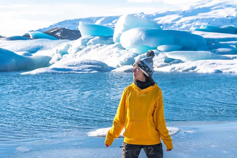 Portrait of a woman on the ice of the frozen lake Jokulsarlon during her vacation in Iceland