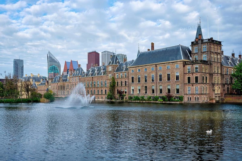 View of the Binnenhof House of Parliament and the Hofvijver lake with downtown skyscrapers in background. The Hague, Netherlands