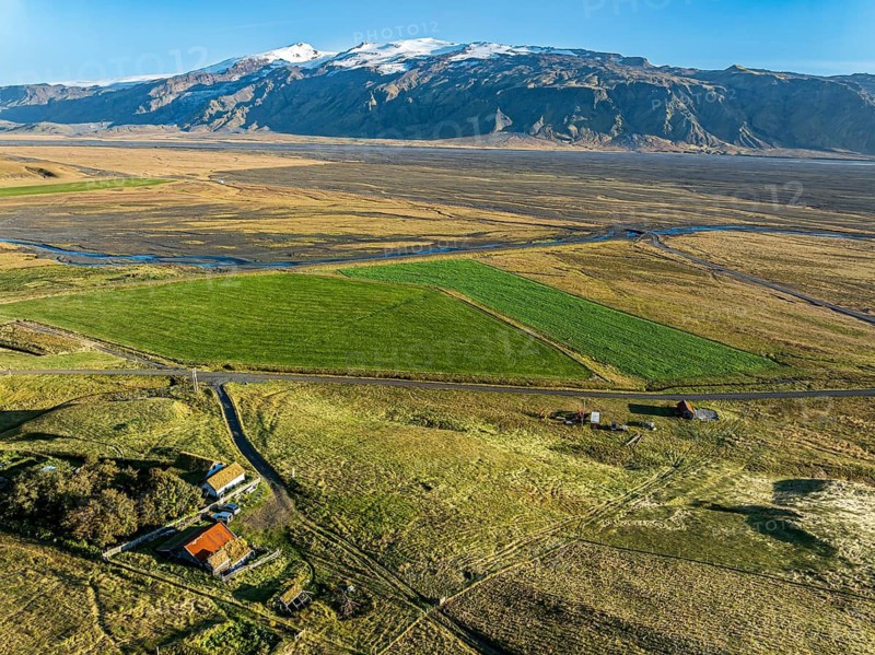 Grazing sheep, aerial view over meadows to glacier Eyjafjallajökull, Fljotsdalur valley, Iceland