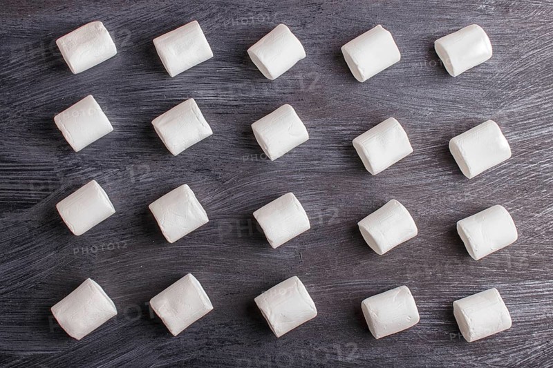Set of marshmallows on black wooden background. top view, flat lay. geometric pattern