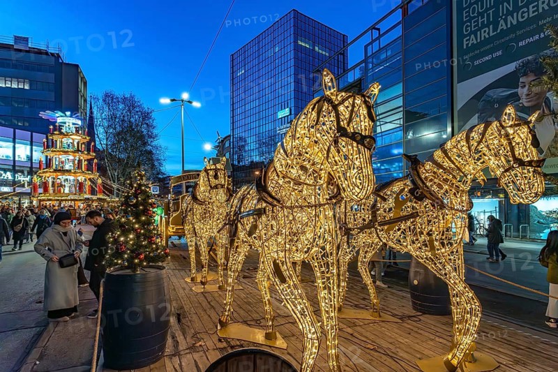 Light installation beer carriage with horses at Dortmund's Christmas market at dusk, Dortmund, North Rhine-Westphalia, Germany