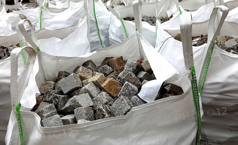 Building site, road construction, granite paving stones packed in big packs, cobblestones