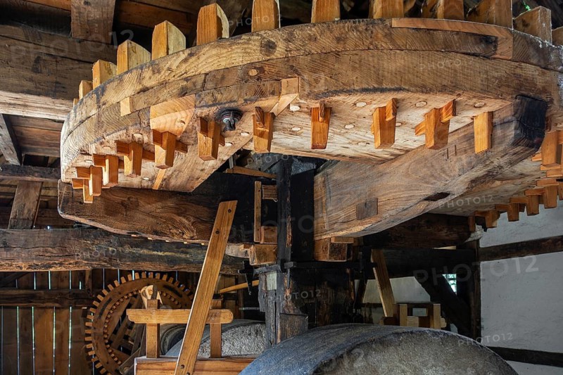 Wooden cogwheels and gear mechanism inside 18th century watermill, water wheel at open air museum Bokrijk, Limburg, Flanders, Belgium