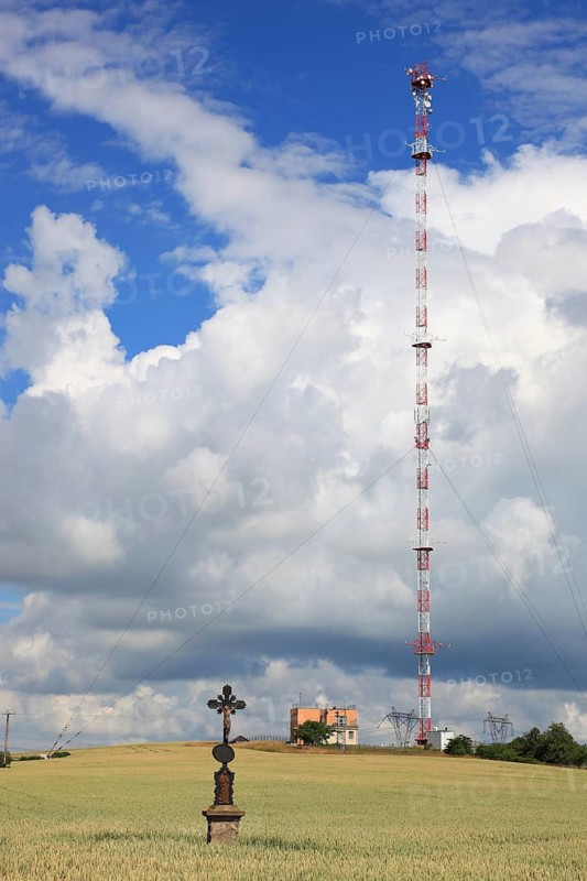 Wheat field, grain field with a lonely field cross, in the background transmitting station with high radio mast, near Dukovany, South Moravia, Kraj Vysocina, Czech Republic