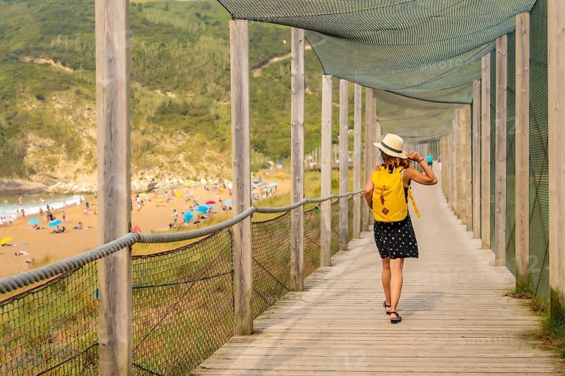 Young and adventurous girl enjoying summer vacation walking alone along the beach