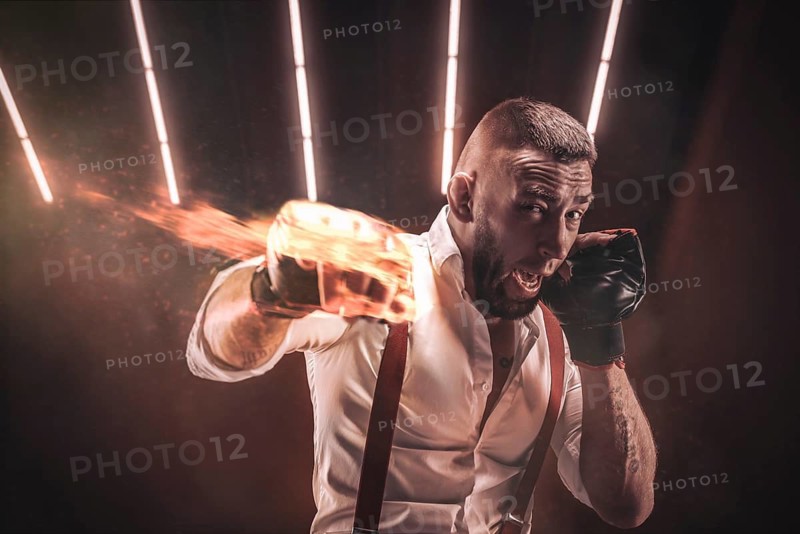 Image of a brutal bearded man boxing in sports pads. Mixed martial arts. The concept of fist fights.