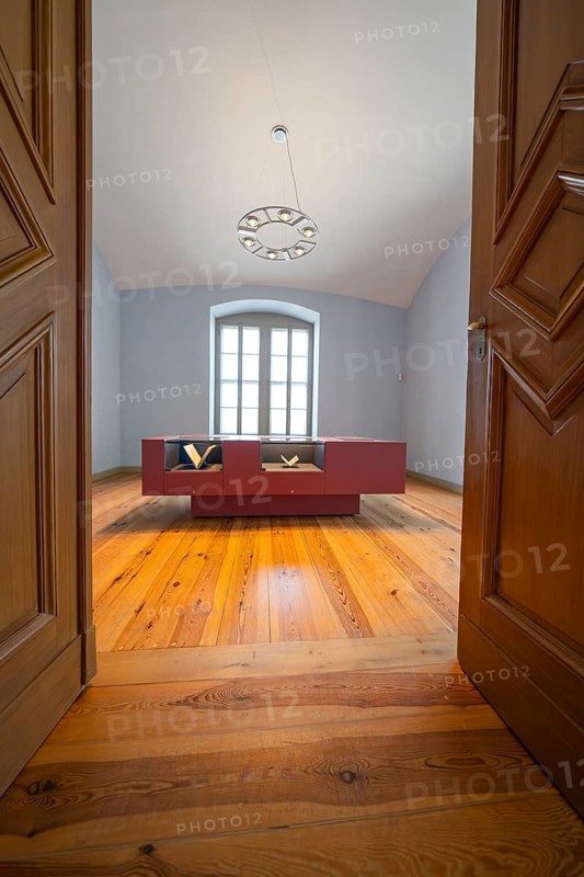 Simply furnished interior with a wooden floor and a modern table in front of a window, Weimar, Germany