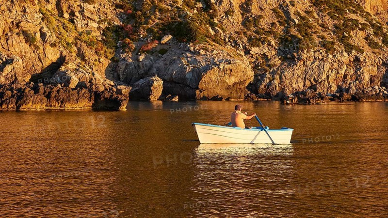 Rowing boat, man rowing, morning light, Marettimo, Egadi Islands, Sicily, Italy