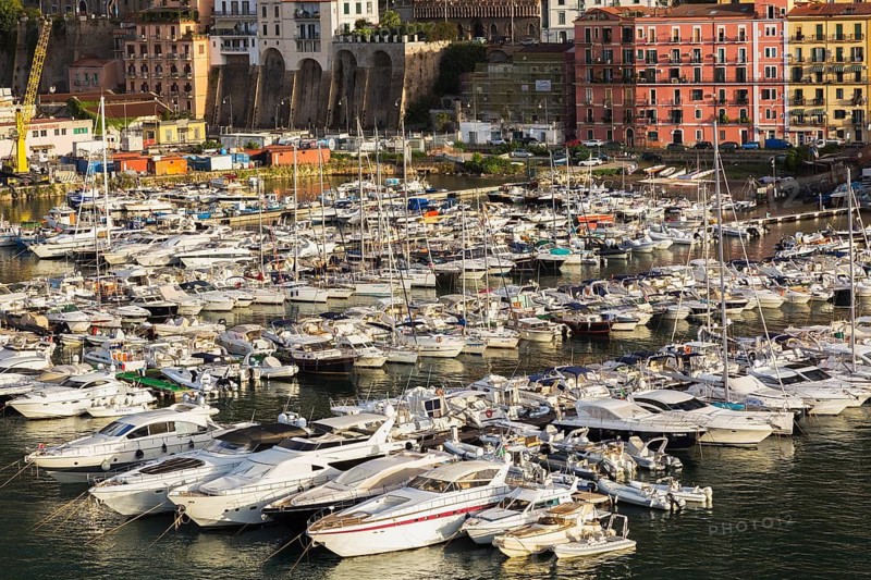 High angle view of marina with luxurious private yachts and sailboats bordered by apartment buildings in late summer, Port of Salerno, Campania region, Italy