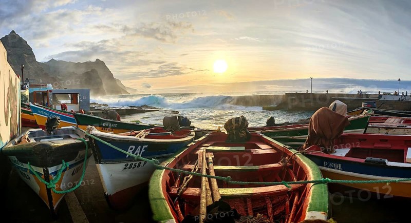 Fishing boats on the shore with dramatic sunset in the background, waves making waves across the pier, romantic harbor scene, Ponta do Sol, Santo Antao, Cabo Verde, Cape Verde, Cape Verde