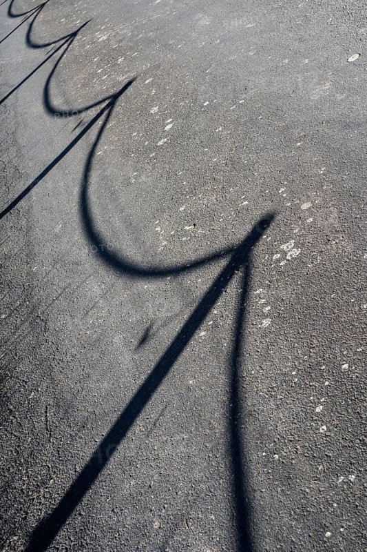 A street with the shadow of a fence